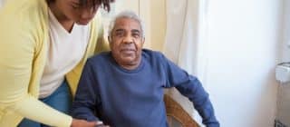 home health aide helping elderly man