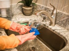 person washing glass in sink