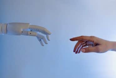 robot and human hand reaching out to each other