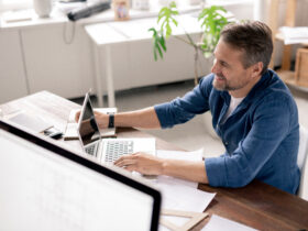 happy. smiling man looking at laptop at desk in home office