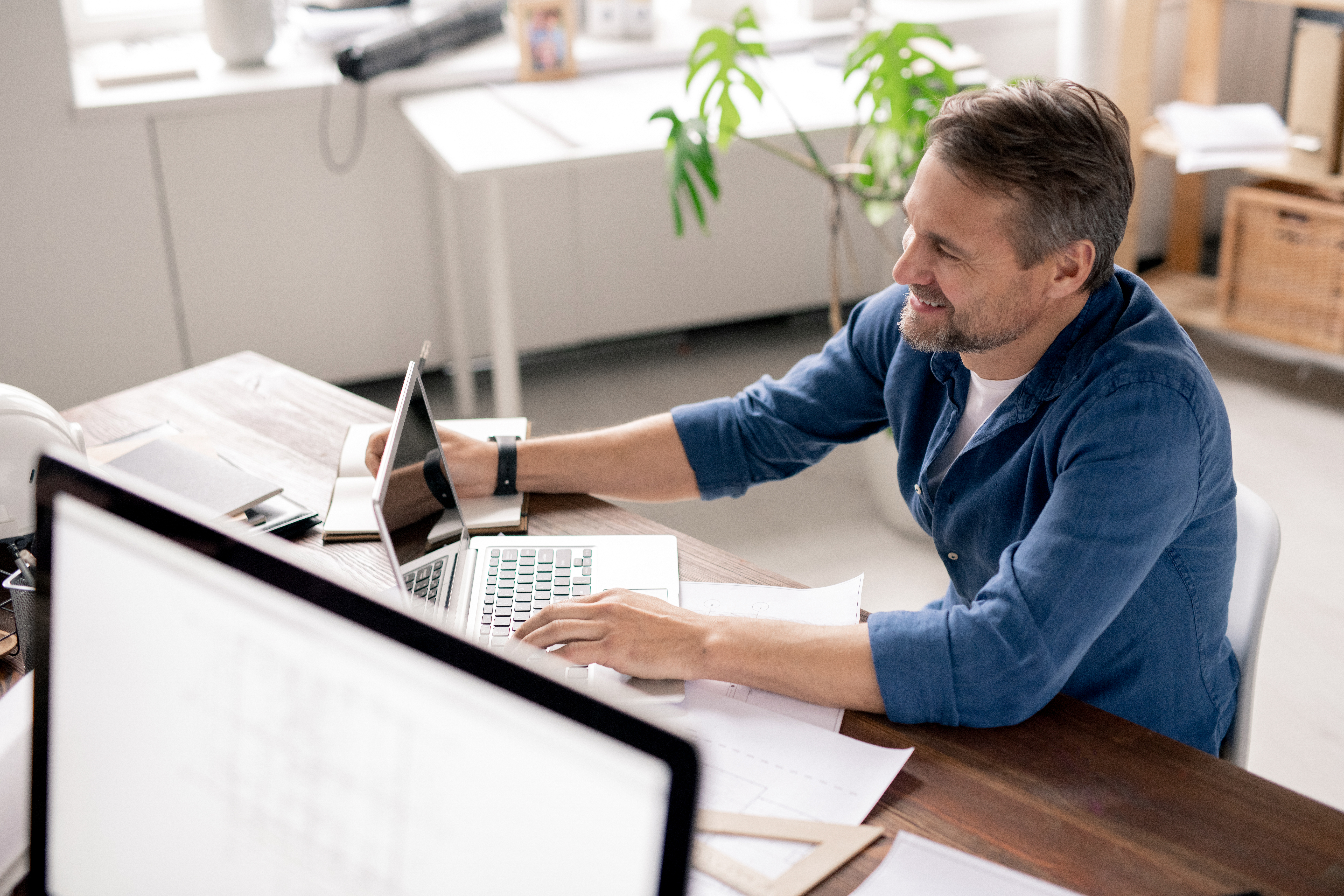happy. smiling man looking at laptop at desk in home office