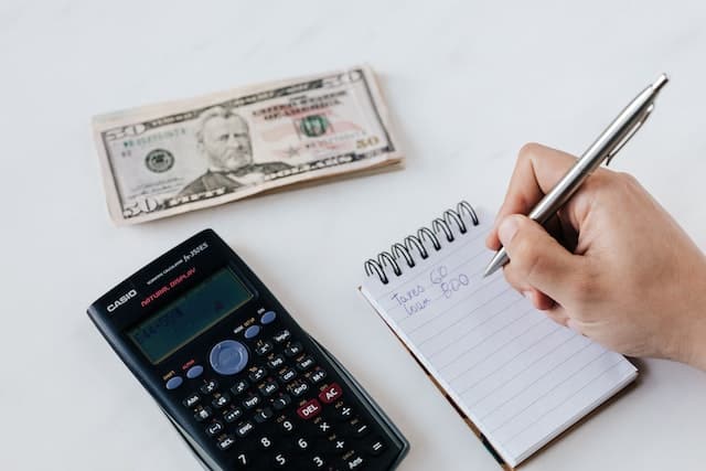 cash, notebook, and calculator on table
