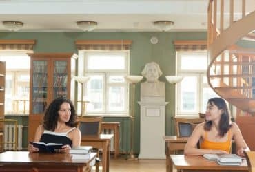 two university students at desks looking at each other