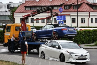 car being loaded onto flatbed trailer for transport