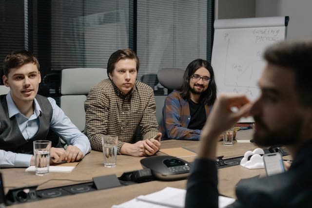 men sitting around a conference table talking