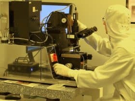 scientist on a microscope inside a cleanroom