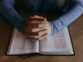 man praying over an open Bible