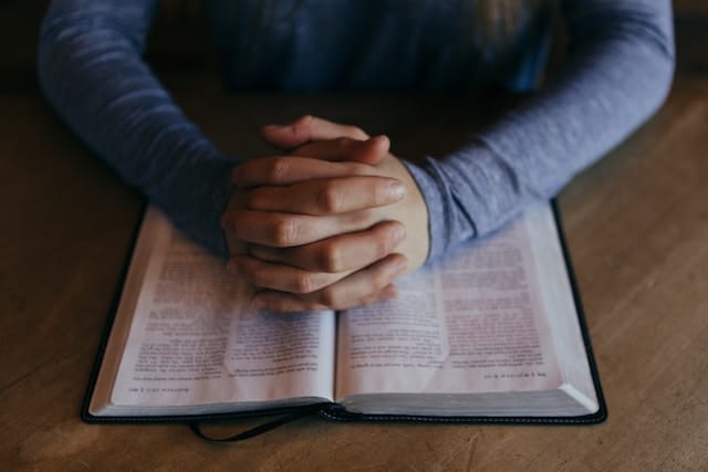 man praying over an open Bible