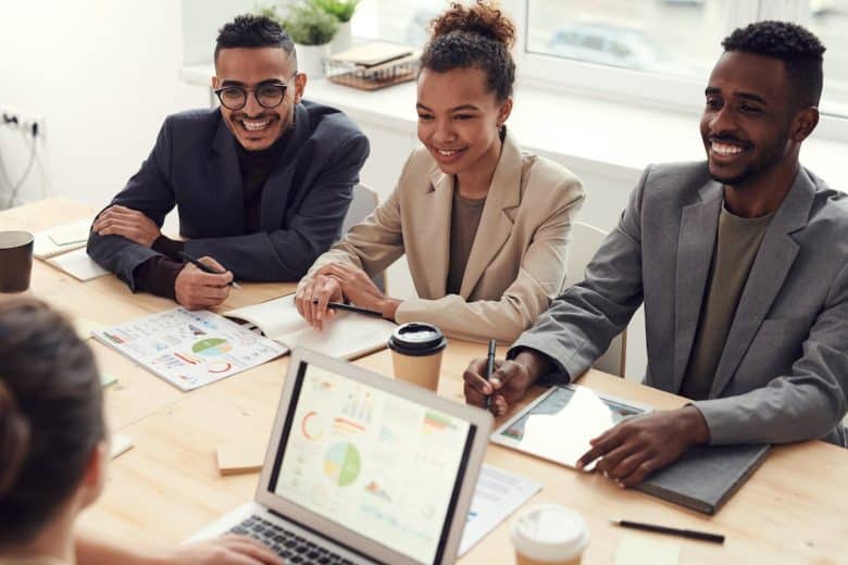 two men and a woman sitting at a conference table