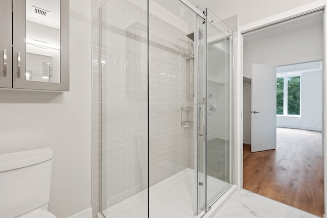 glass shower stall in a bright bathroom connected to a closet and bedroom