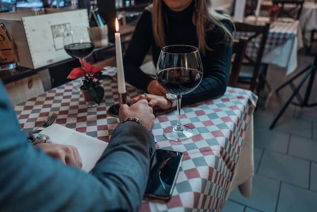couple holding hands on the table while on a dinner date