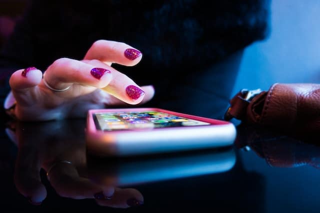 woman's hand hovering over a smartphone