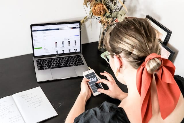 woman shopping online with her phone and laptop