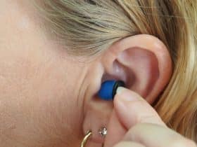 woman touching a hearing aid in her ear