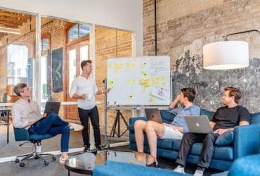 team of employees sitting around discussing goals and strategies