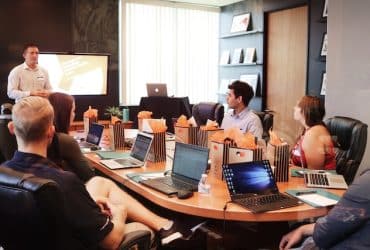 man leading a meeting in a conference room full of people