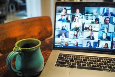 laptop displaying an online meeting with many participants.