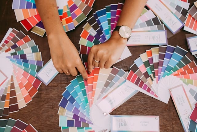 woman looking at several paint color palette wheels