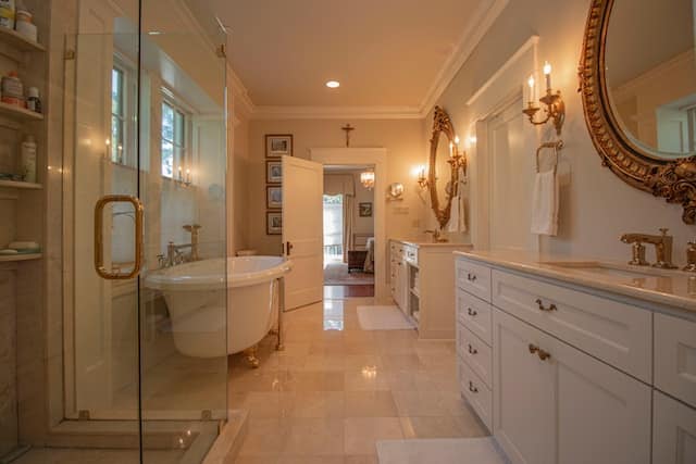 large, fancy bathroom with tile floors and gold fixtures
