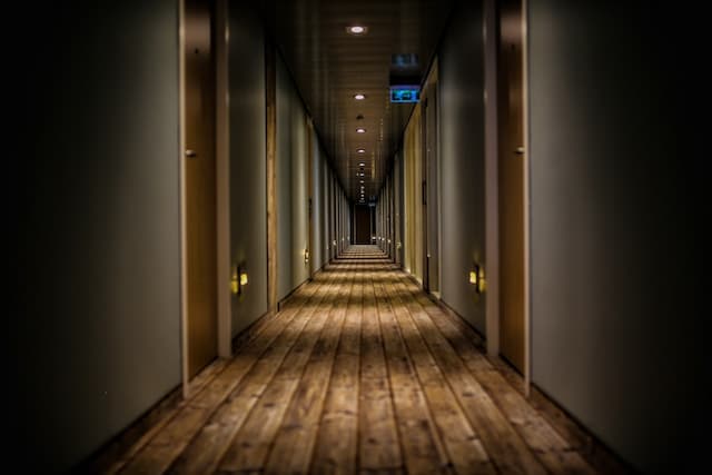 long hotel hallway with wood flooring