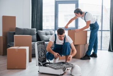 two young men packing boxes for moving