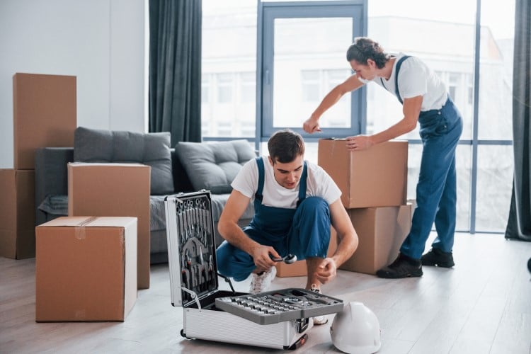 two young men packing boxes for moving