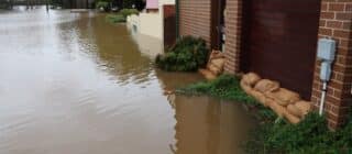 exterior of a house flooded and using sandbags