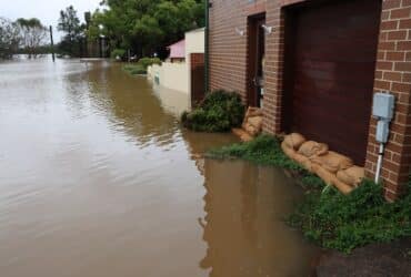 exterior of a house flooded and using sandbags