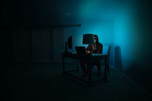 hacker with a mask working at a desk