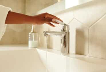 woman running water in a bathroom sink