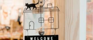 metal welcome sign with a cat on top