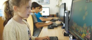 children at computers in school playing a typing game