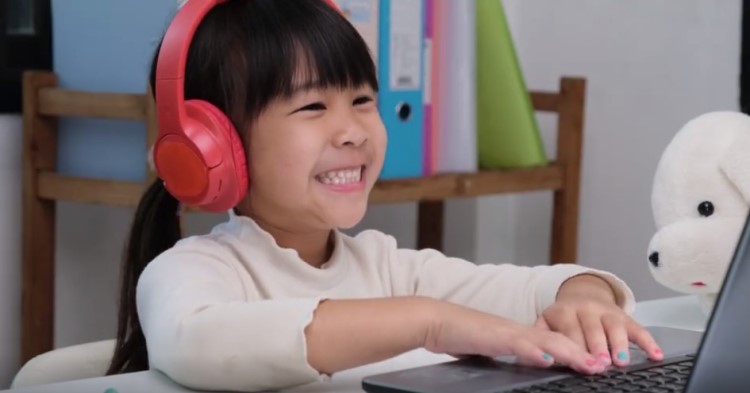 girl smiling while she plays a computer game