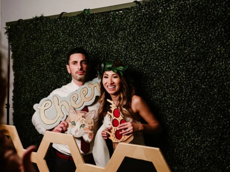 A couple taking pictures at a photo booth at an event