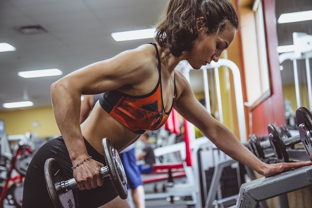 woman using barbells in a gym