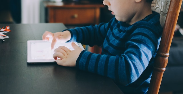 a boy playing on a tablet