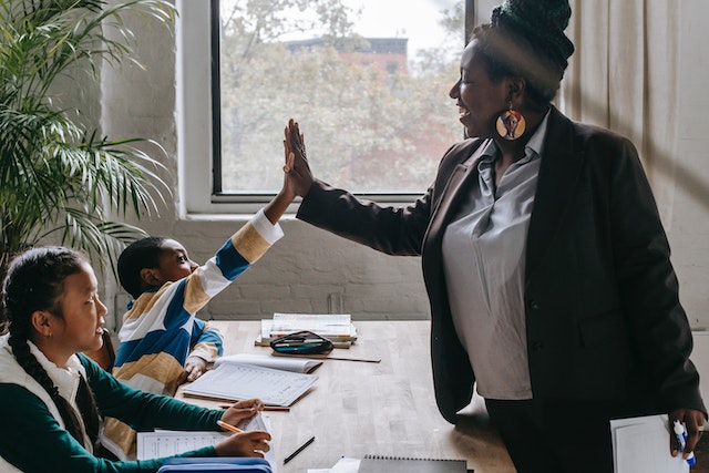 teacher high-fiving a student in class