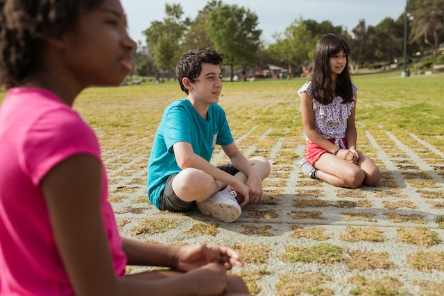 kids sitting outside in the grass