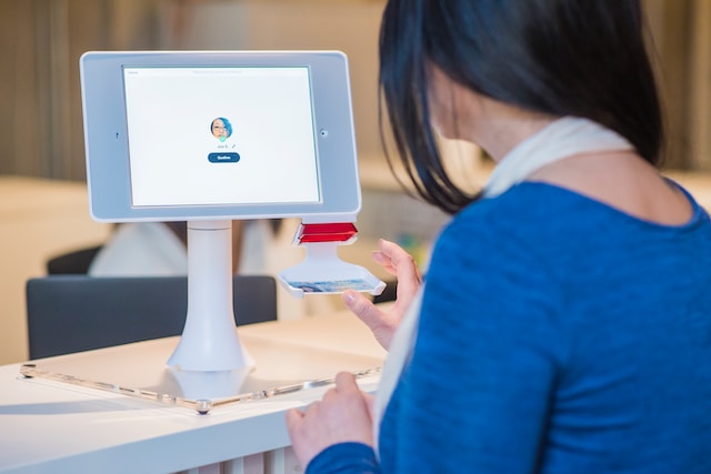 a woman using her drivers license in an identity management kiosk