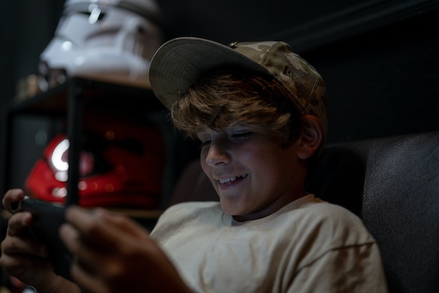 a boy sitting in his room playing on his smartphone