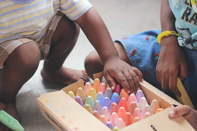 children looking through a box of giant chalk