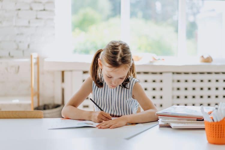 a girl drawing in a workbook