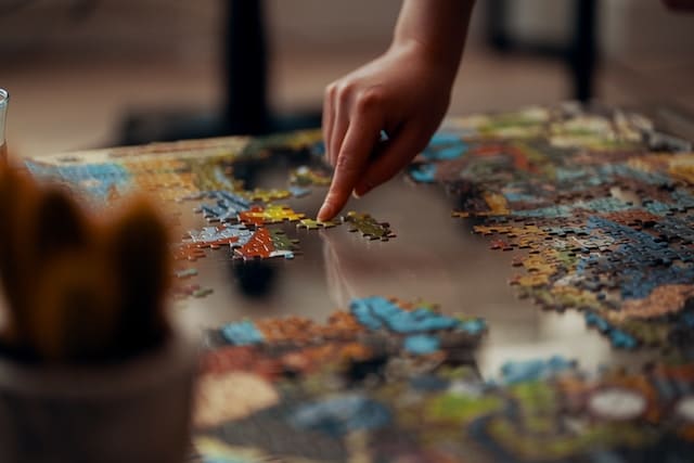 a child's hand moving a puzzle piece into the correct spot