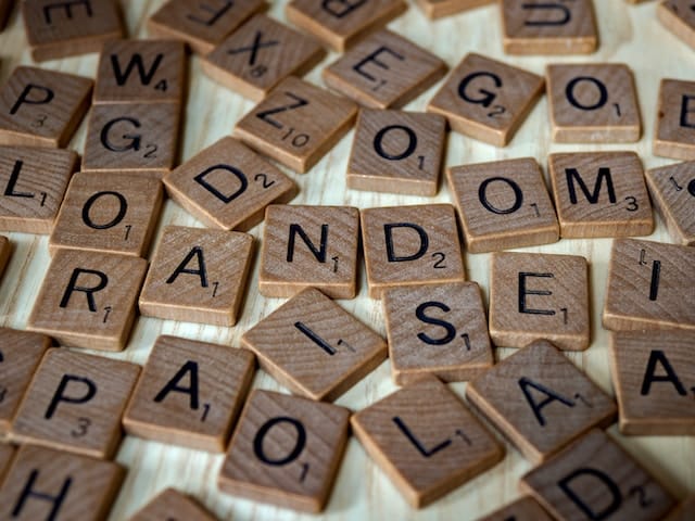 Scrabble letters scattered on a table, with some of them arranged to spell "random".