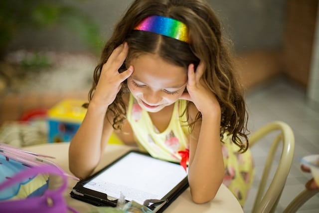 2nd grade girl playing a spelling game online on a tablet