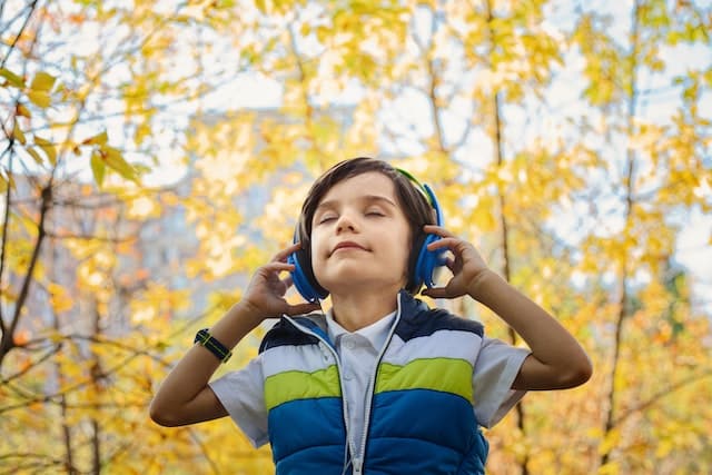 a boy happily listening to music through headphones