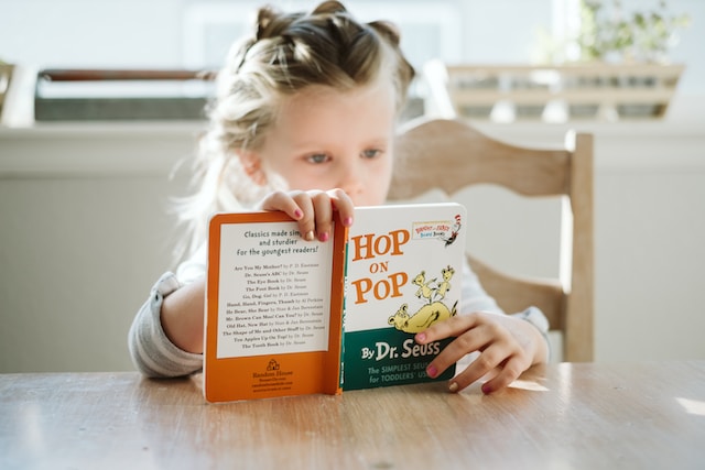 young girl reading a Dr. Seuss book