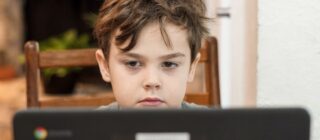 young boy sitting bored in an online class
