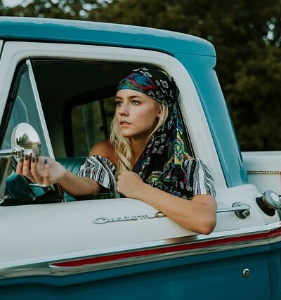 woman driving an old blue truck