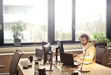 man working on computers IT Business headphones office